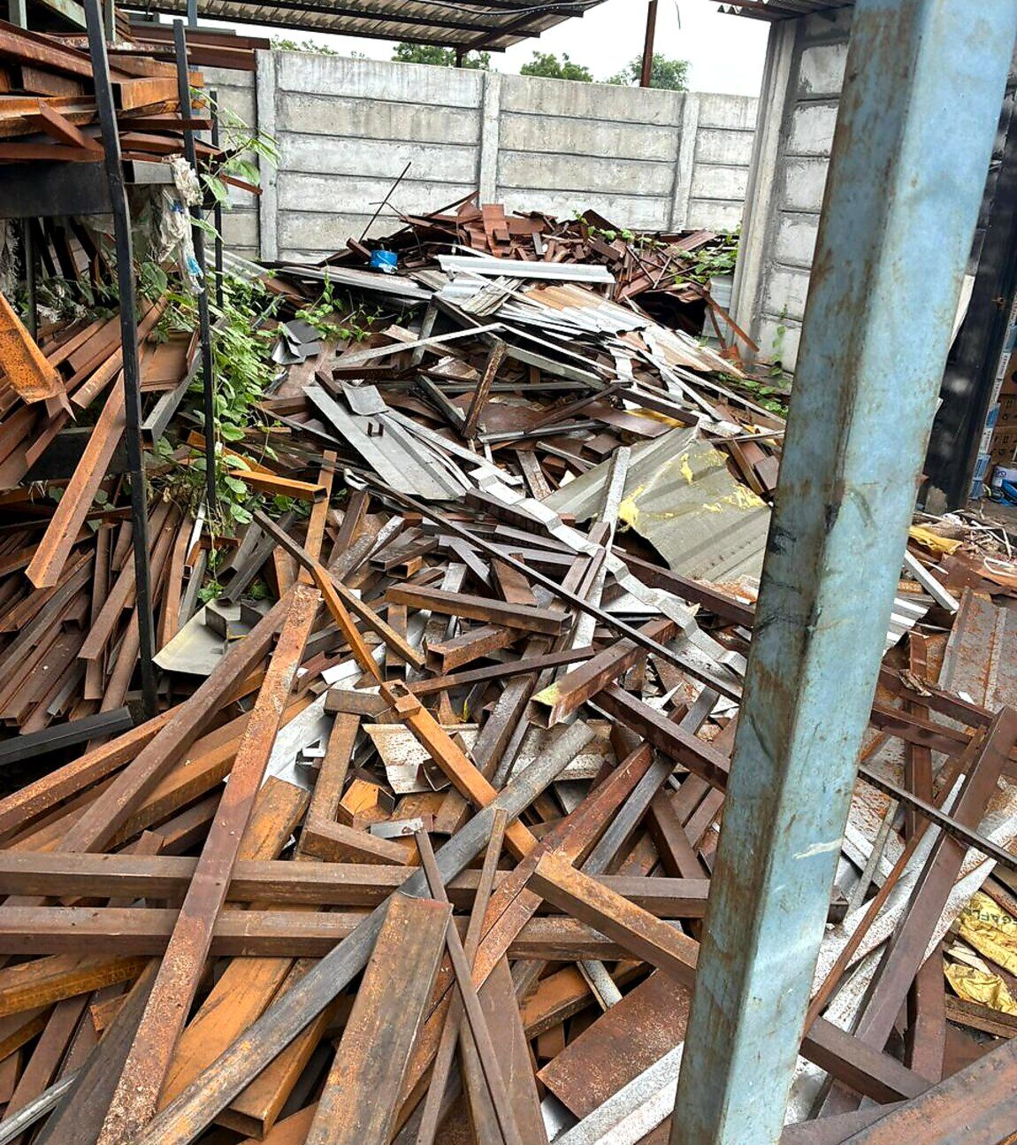Structural steel offcuts stacked under the yard shed